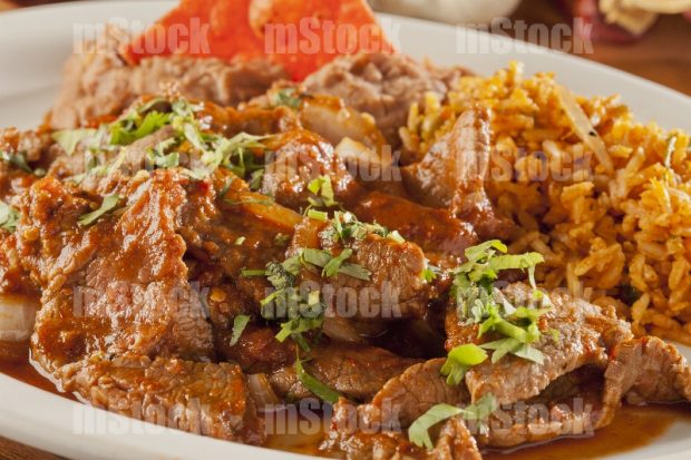 Milanesa de res en salsa roja con arroz y frijoles