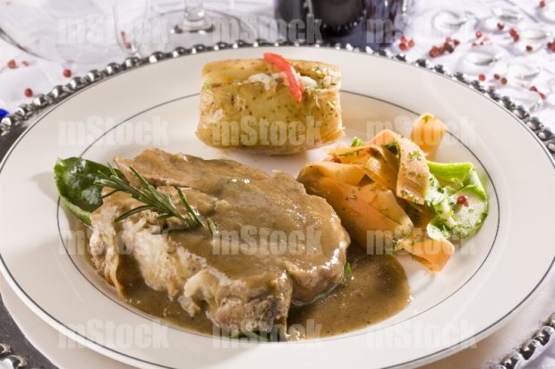Chuleta de cerdo con gravy y verduras