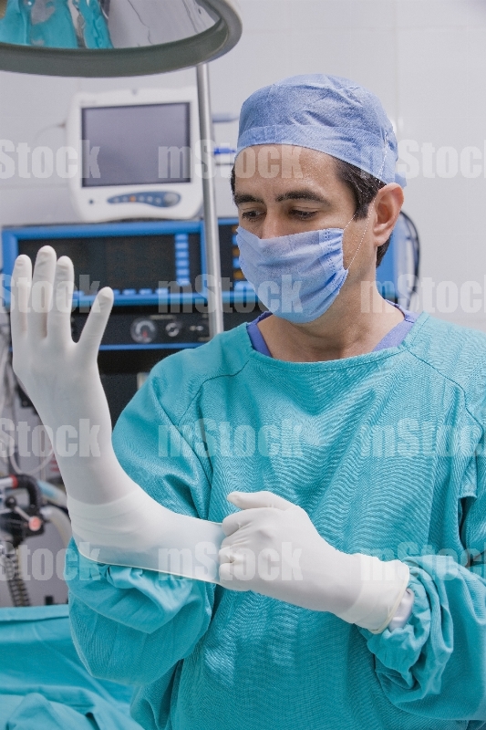 Médico poniéndose guante 1