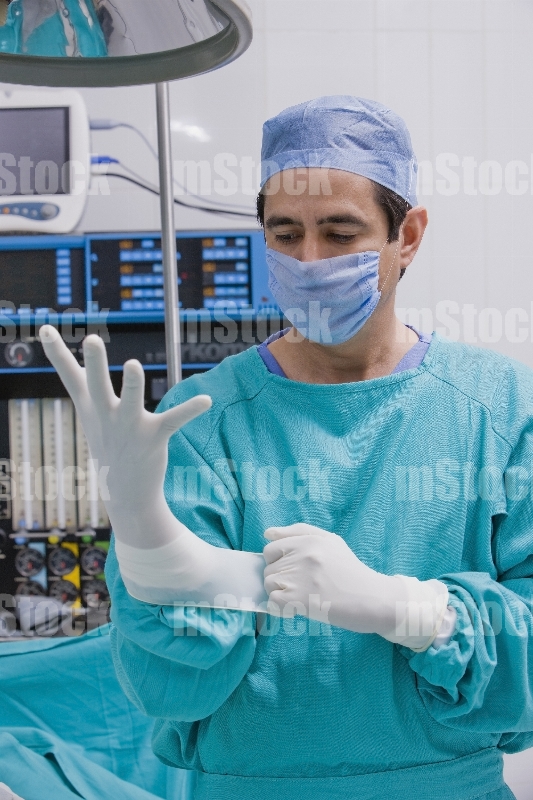 Médico poniéndose guante 2