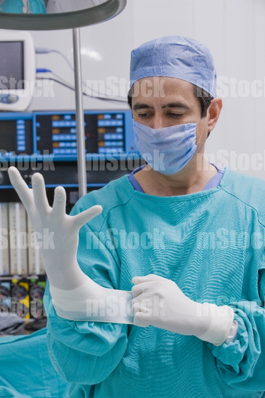 Médico poniéndose guante 3
