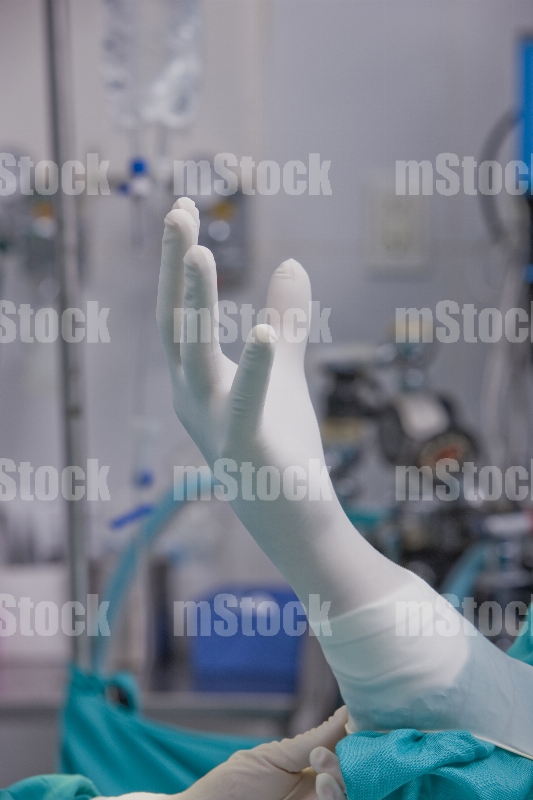 Médico poniéndose guante 4