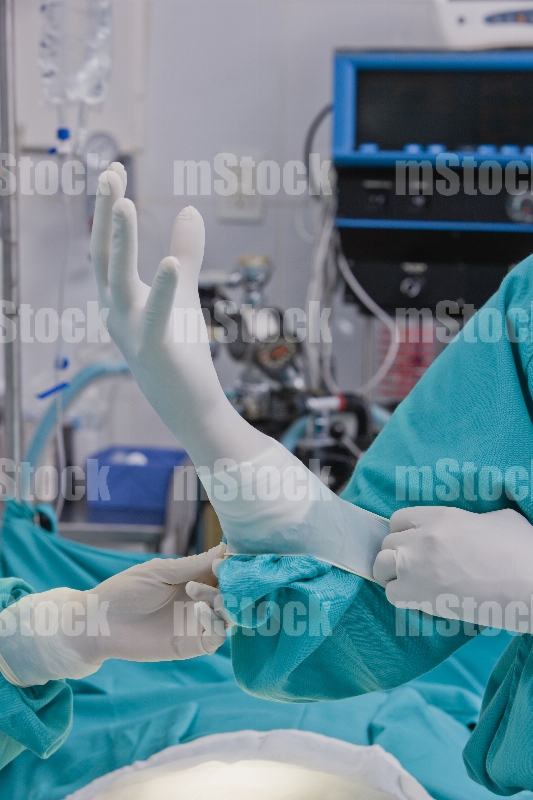Médico poniéndose guante 5