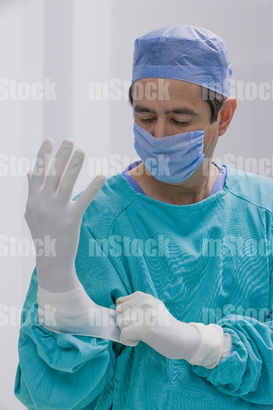 Médico poniéndose guante