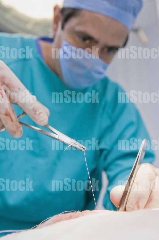 Cirujano Médico cosiendo en cirugia 3