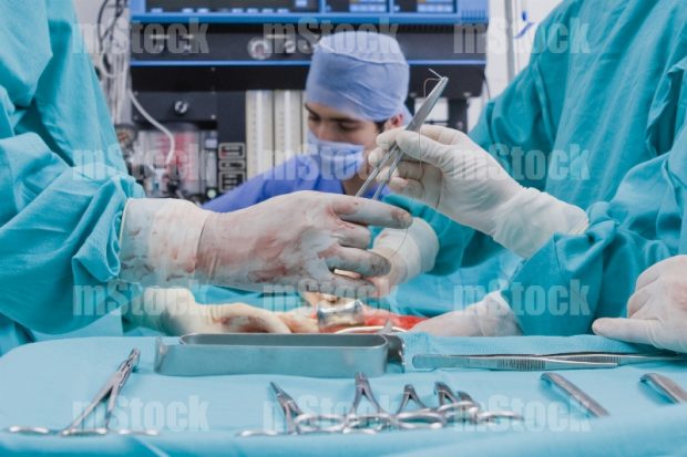 Cirujano Médico cosiendo en cirugia
