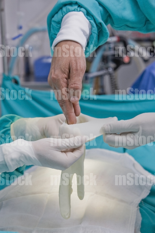 Cirujano poniéndose los guantes 1