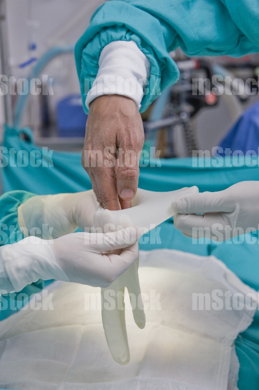Cirujano poniéndose los guantes 2