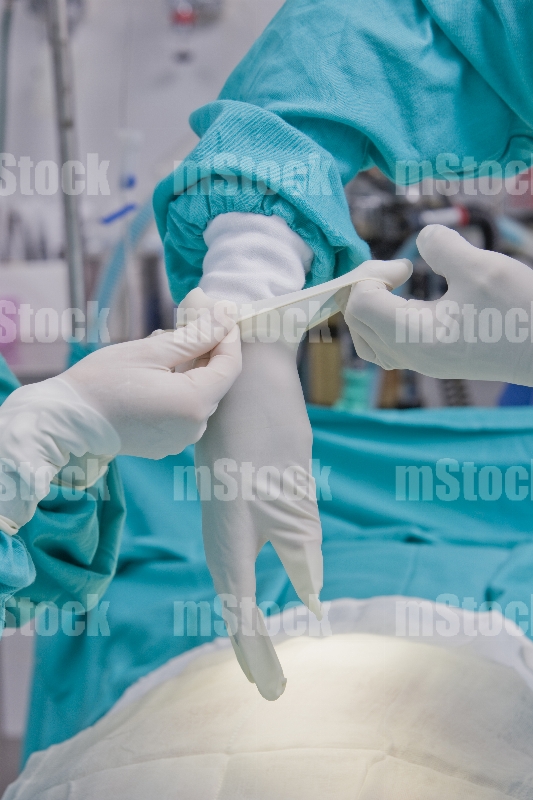 Cirujano poniéndose los guantes 3