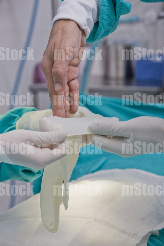 Cirujano poniéndose los guantes