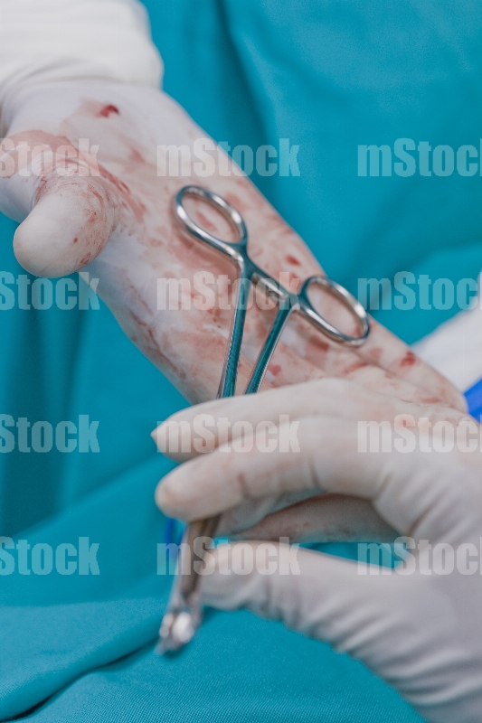 Doctor con pinzas en Quirófano 1