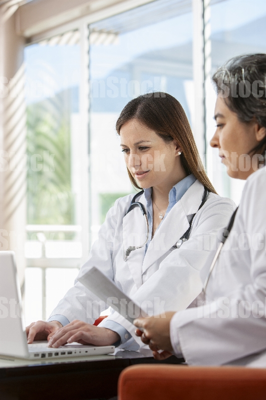 Doctoras revisando informe médico