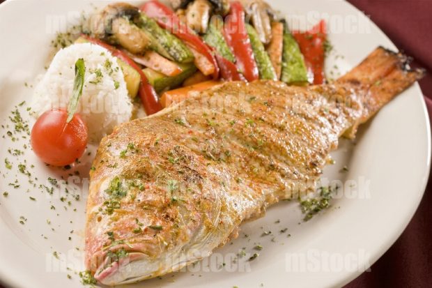 Pescado frito entero con arroz y verduras