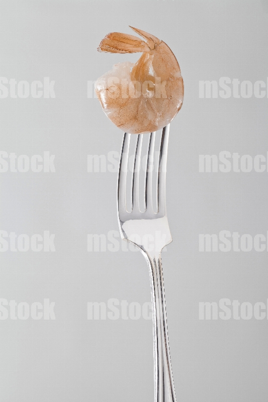 Camarón crudo con cáscara en tenedor