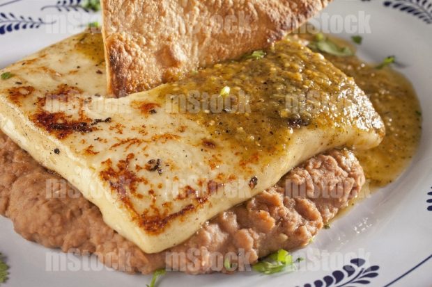Queso Panela asado con salsa sobre frijoles