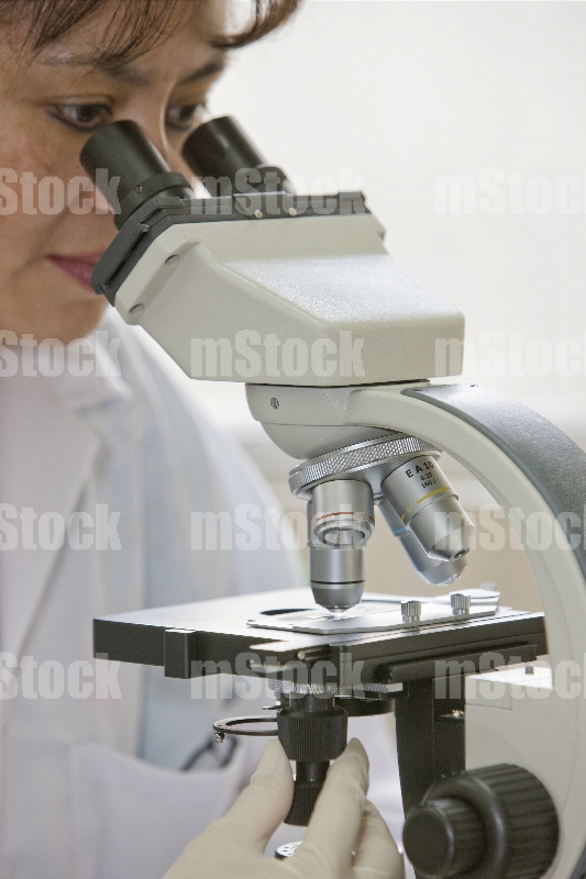 Doctora utilizando microscopio