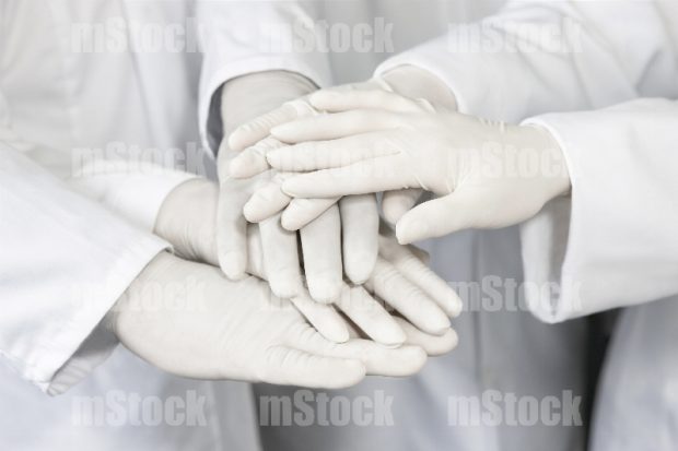 Manos de doctores con guantes en equipo