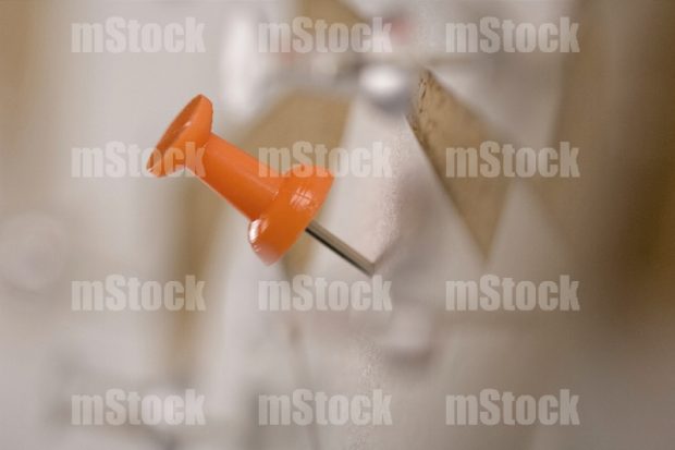 Pin sobre papel en pizarra de corcho