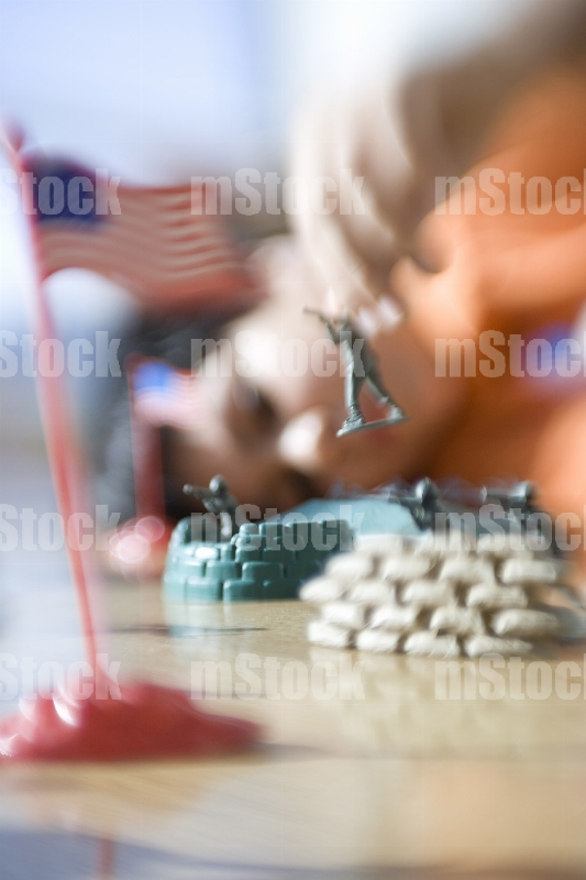Niño jugando con soldaditos de juguete