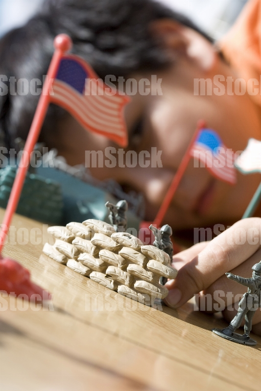 Niño jugando con soldados de plastico