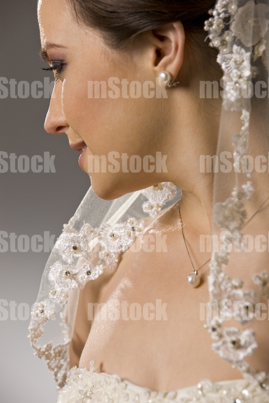 Novia con accesorios de perlas y velo corto
