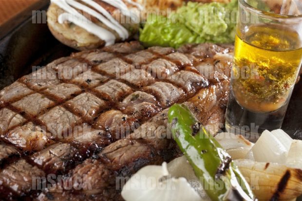 Rib eye a la parrilla con papa asada y guacamole