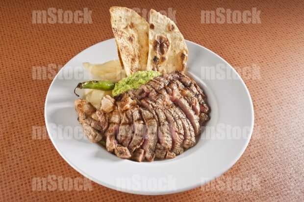 Rib eye sin hueso con cebolla y guacamole